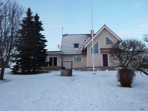 Back view of remodeled house from the river side .  Old apple trees grow in the yard.